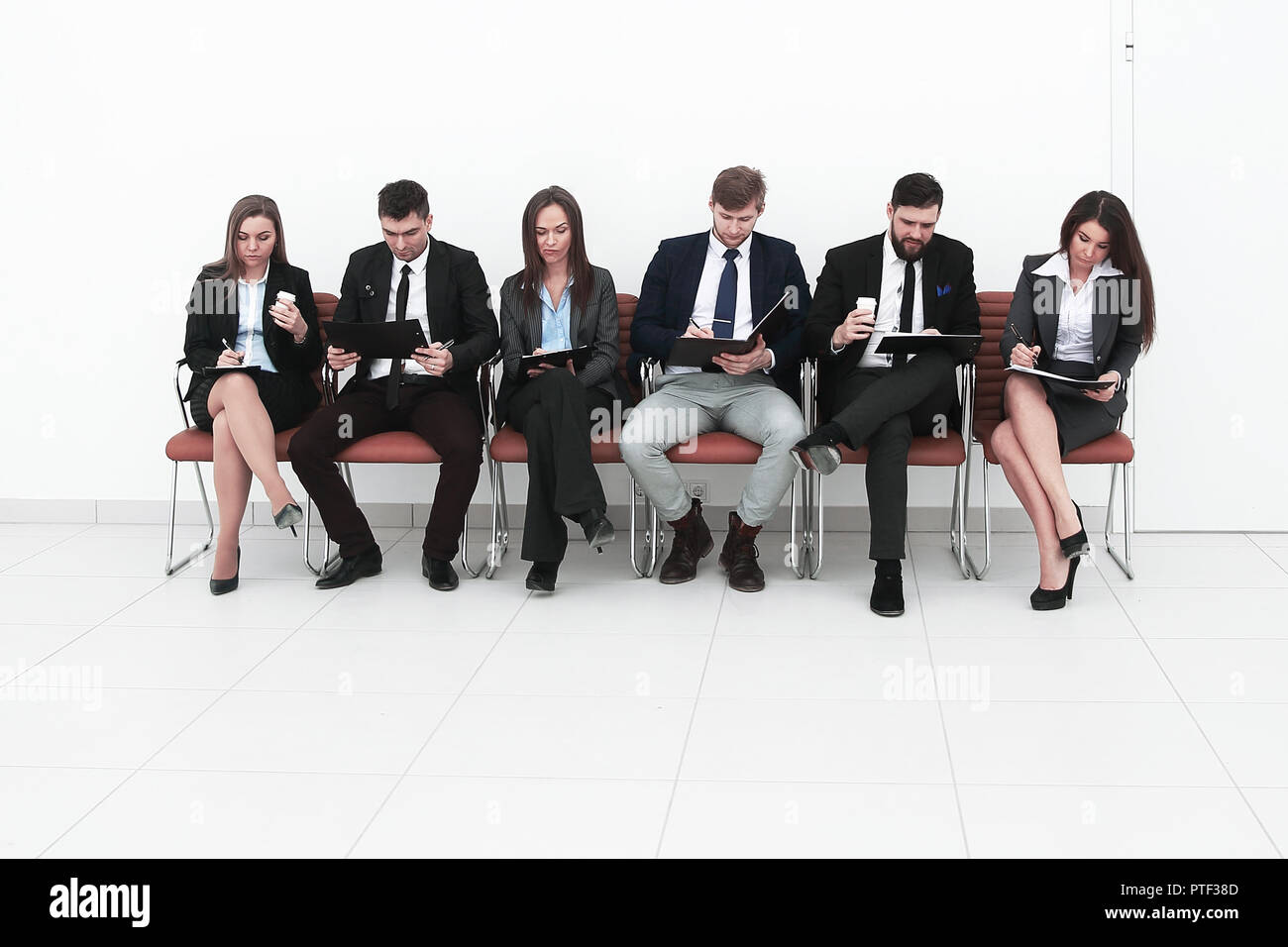 business team with clipboards sitting in a row Stock Photo - Alamy