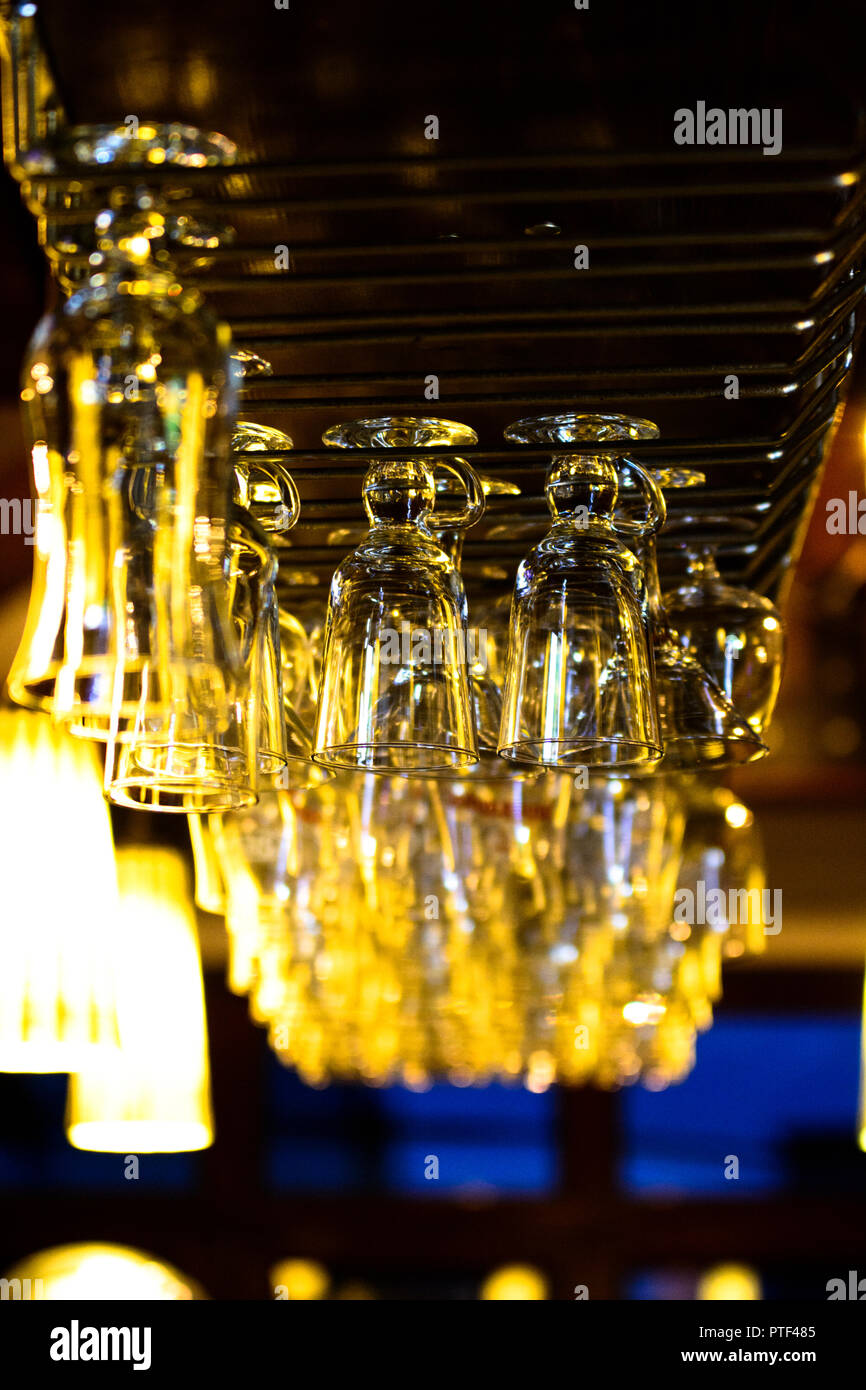 Glasses on a bar hanging upside down. The bar counter in the cafe Stock