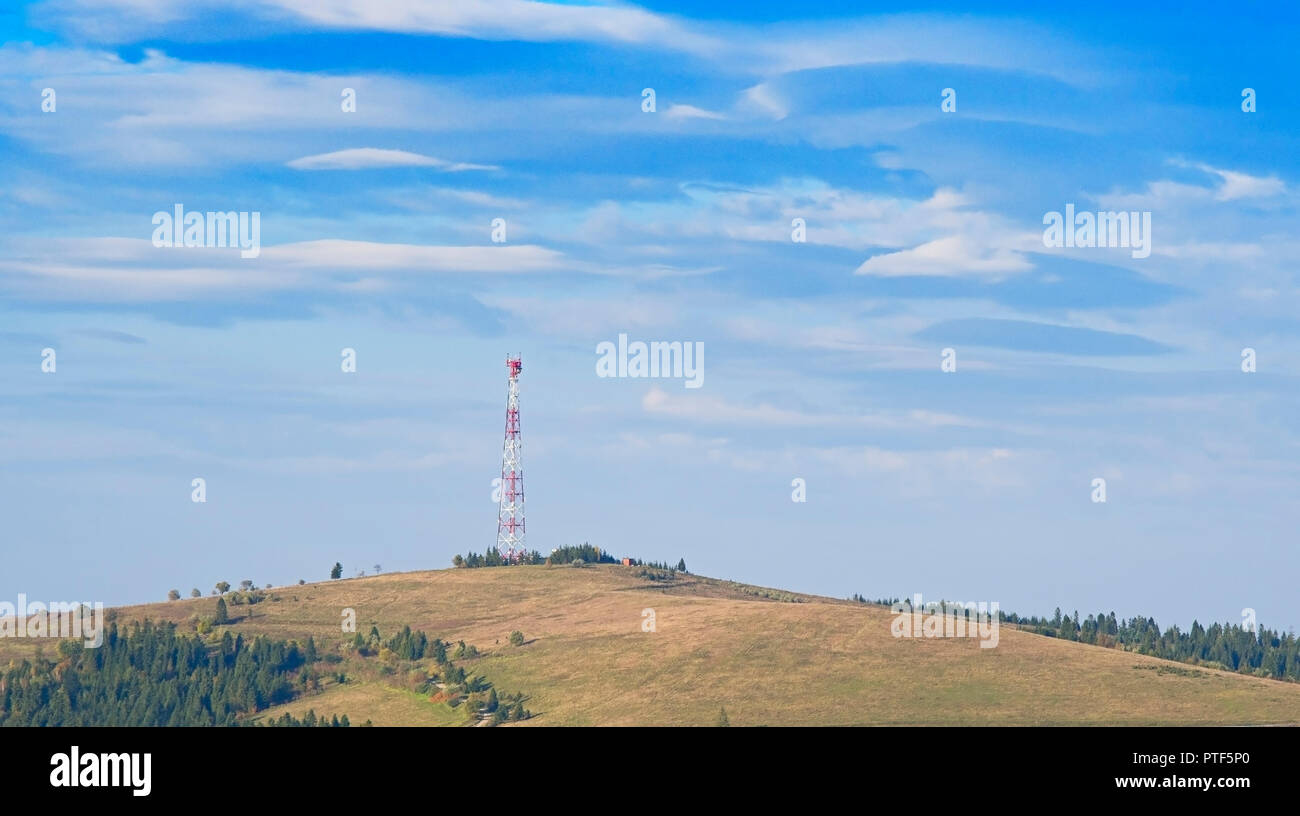 mobile phone telecommunication tower with white cloud and blue sky mountain background Stock Photo