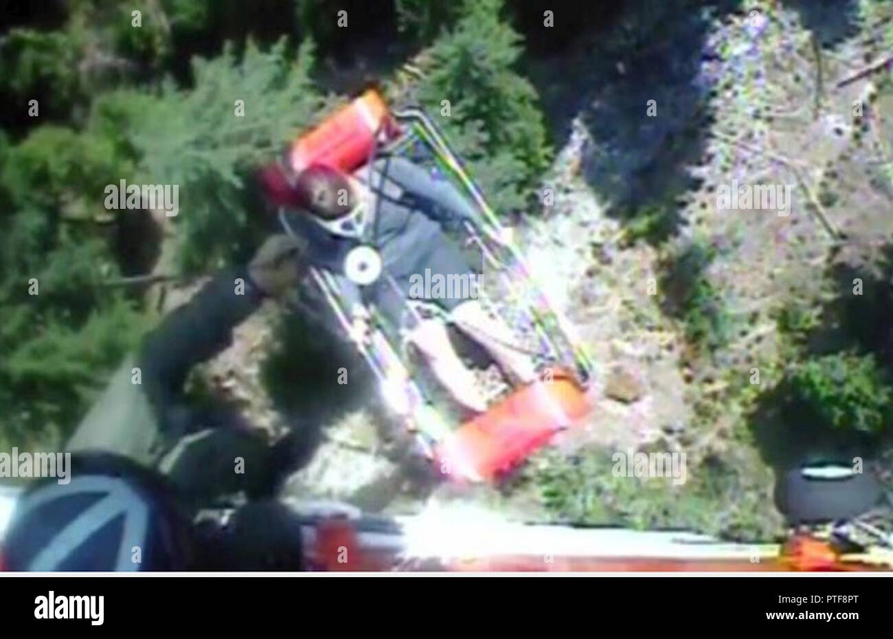 A Coast Guard helicopter crew hoists 40-year-old female hiker to safety near Agness, Oregon, after she was reported missing and spent the night near Game Lake Trail in Rogue River-Siskiyou National Forest, July 20, 2017. The aircrew aboard an MH-65 Dolphin helicopter from Coast Guard Sector North Bend hoisted the hiker at approximately 12:30 p.m. and transferred her to the Curry County Sheriff Department who were waiting in Agness. Stock Photo