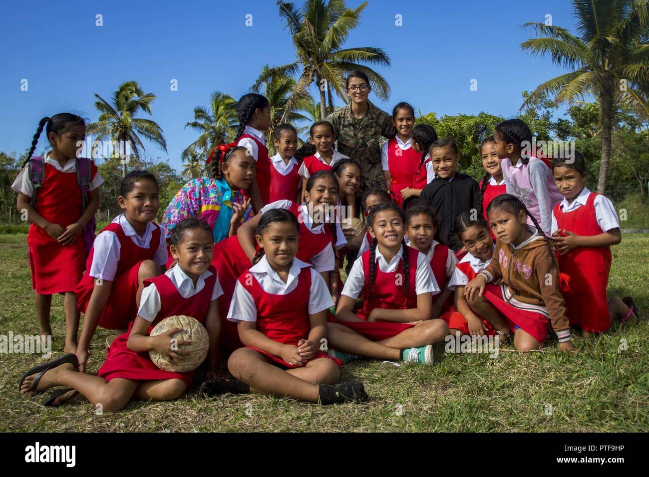 U.S. Marine Corps Cpl. Christy Barron, an ammo tech with Combat Logistics Battalion 3 attached to Task Force Koa Moana 17, poses for a photo with school children at Lapaha Elementary School as a part of Exercise TAFAKULA, on Tongatapu Island, Tonga, July 20, 2017. Exercise TAFAKULA is designed to strengthen the military-to-military, and community relations between Tonga’s His Majesty’s Armed Forces, French Army of New Caledonia, New Zealand Defense Force, and the United States Armed Forces. Stock Photo