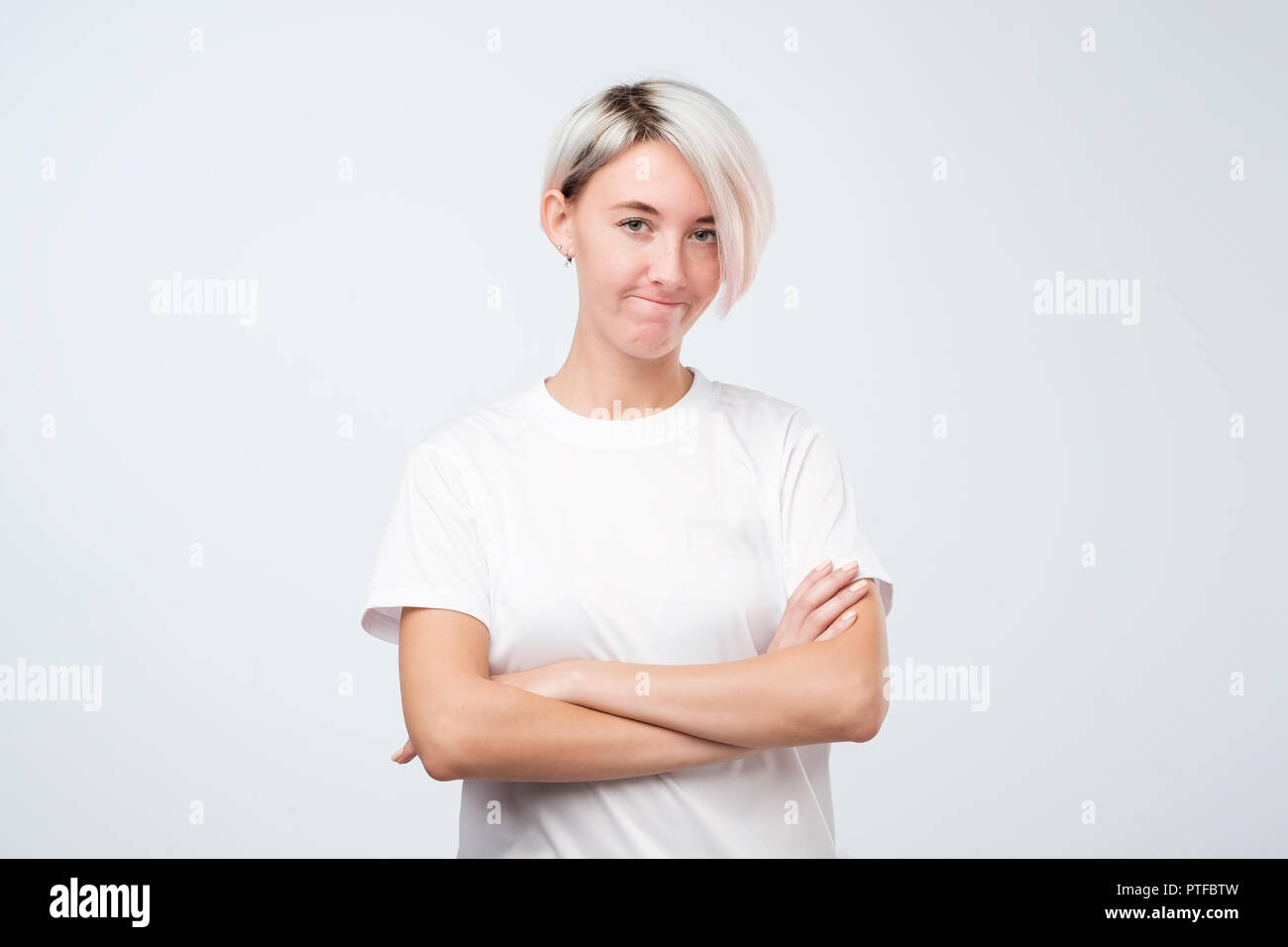 Suspicion, mistrust and distrust concept. Doubtful woman with short colored hair looking with disbelief expression Stock Photo