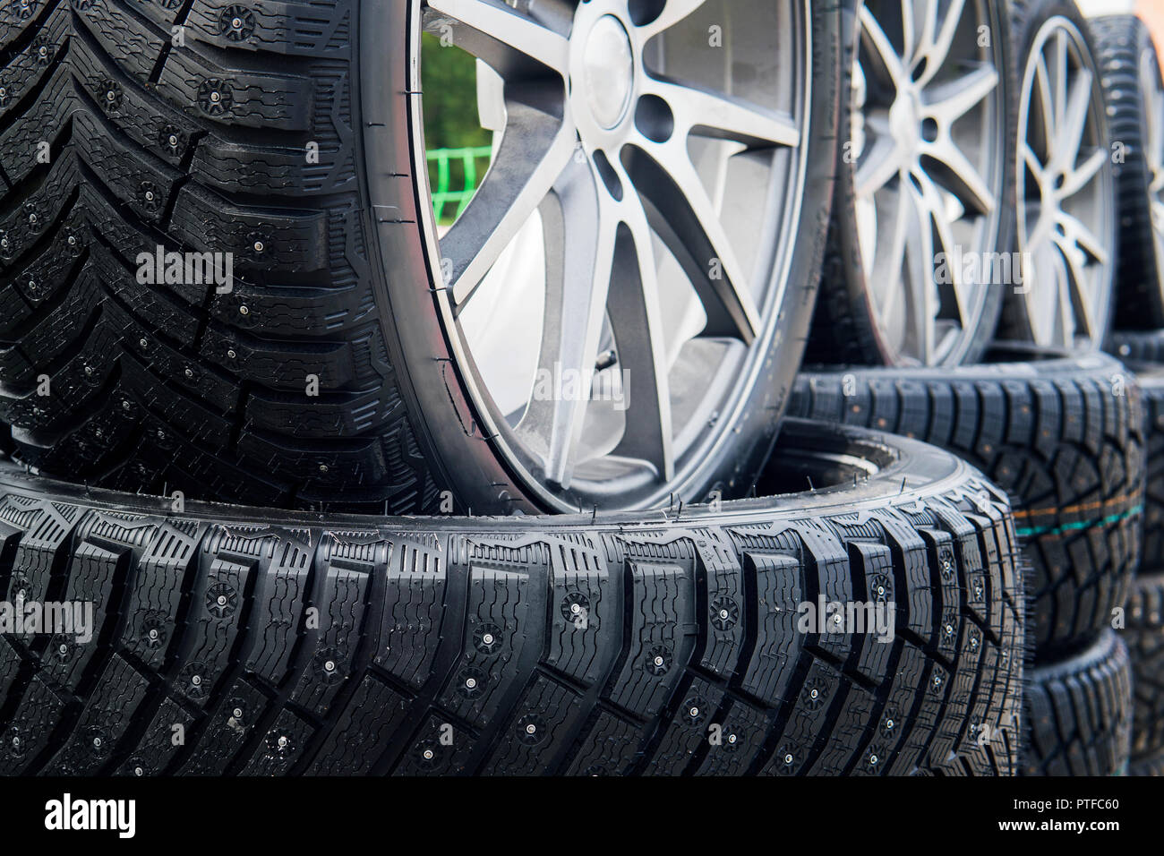 A close up of a lined winter studded wheels set outdoors. Close up of the studs and protectors on tires installed on the street. Winter tires position Stock Photo