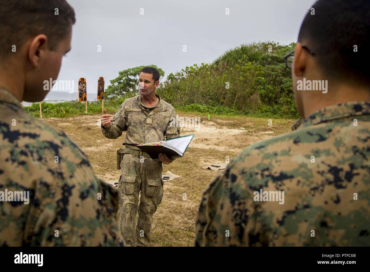 New Zealand Army Sgt. Maj. Paul Buckley, company sergeant major for delta company, explains to U.S. Marines with 3rd Battalion 4th Marines attached to Task Force Koa Moana 17, weapon safety rules prior to participating on a live fire range during Exercise TAFAKULA, on Tongatapu Island, Tonga, July 21, 2017. Exercise TAFAKULA is designed to strengthen the military-to-military, and community relations between Tonga’s His Majesty’s Armed Forces, French Army of New Caledonia, New Zealand Defense Force, and the United States Armed Forces. Stock Photo