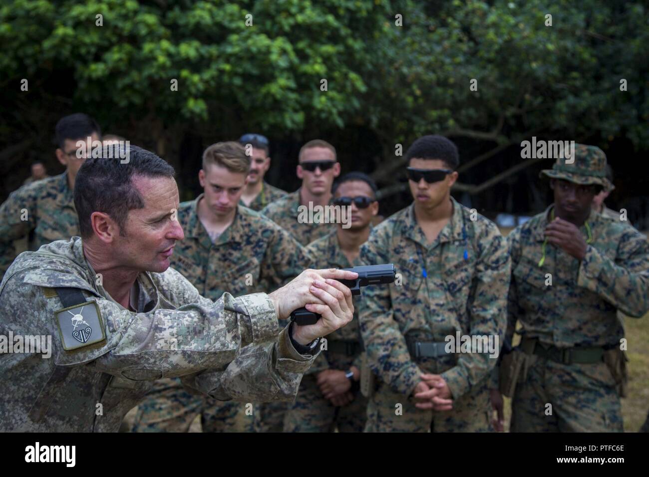 New Zealand Army Sgt. Maj. Paul Buckley, company sergeant major for delta company, shows U.S. Marines with 3rd Battalion 4th Marines attached to Task Force Koa Moana 17, how to use the glock 17 weapon system during Exercise TAFAKULA, on Tongatapu Island, Tonga, July 21, 2017. Exercise TAFAKULA is designed to strengthen the military-to-military, and community relations between Tonga’s His Majesty’s Armed Forces, French Army of New Caledonia, New Zealand Defense Force, and the United States Armed Forces. Stock Photo