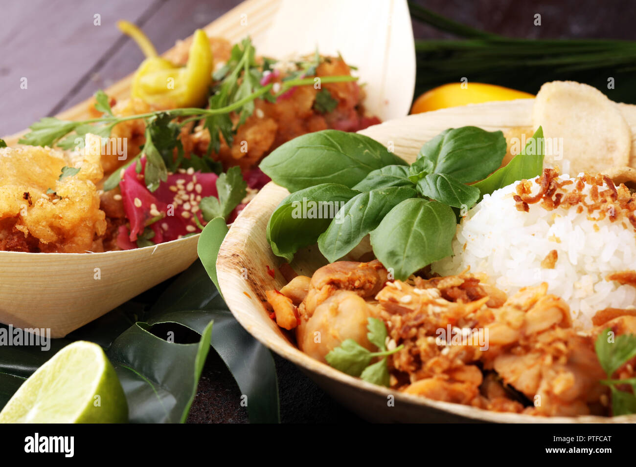 various street food with chicken wings on rustic background. balinese nasi campur and indian and brasilian street food Stock Photo