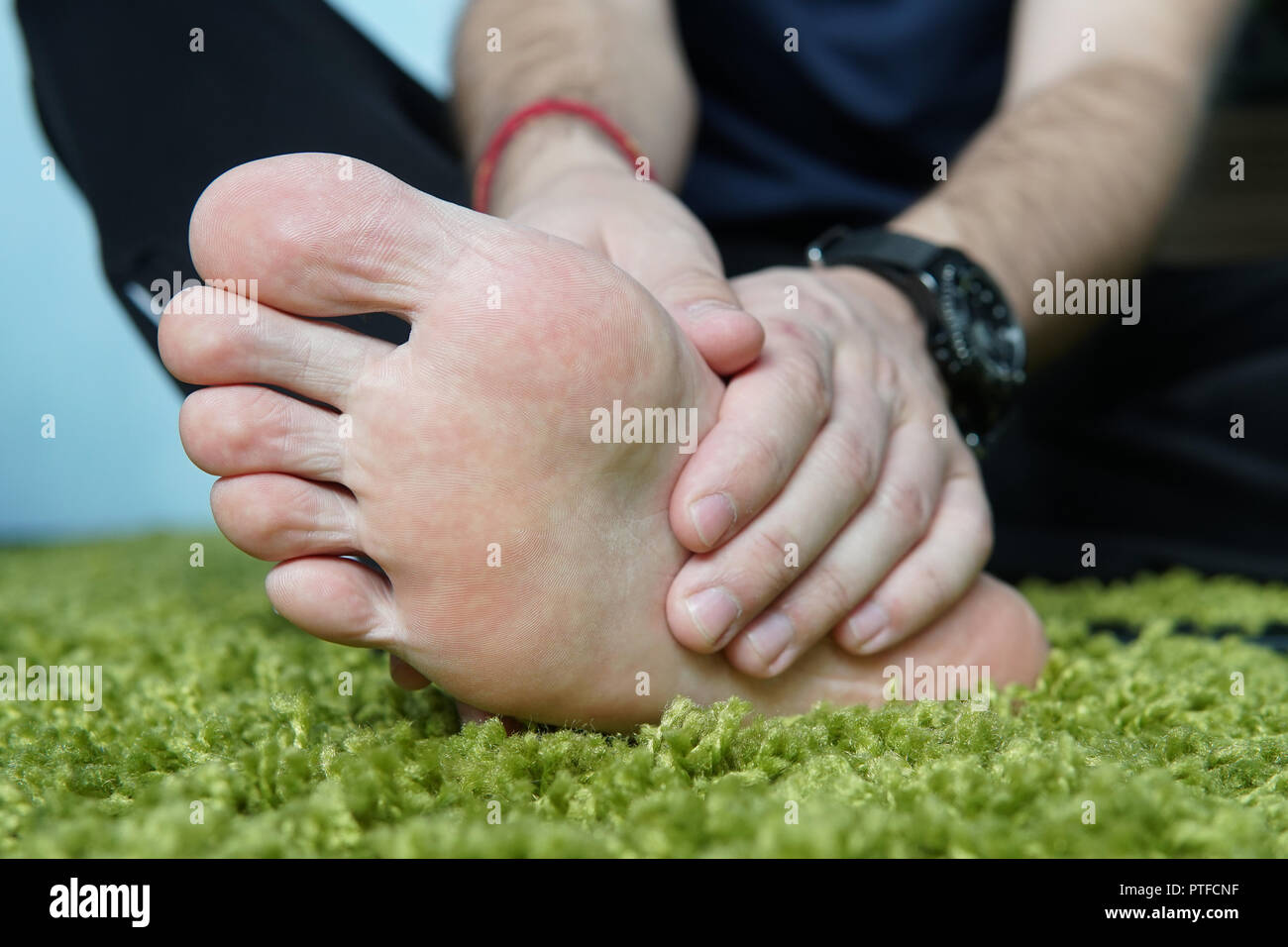Pain in the foot. Massage of male feet. Pedicures. broken foot, a sore foot, massaging the heel Stock Photo