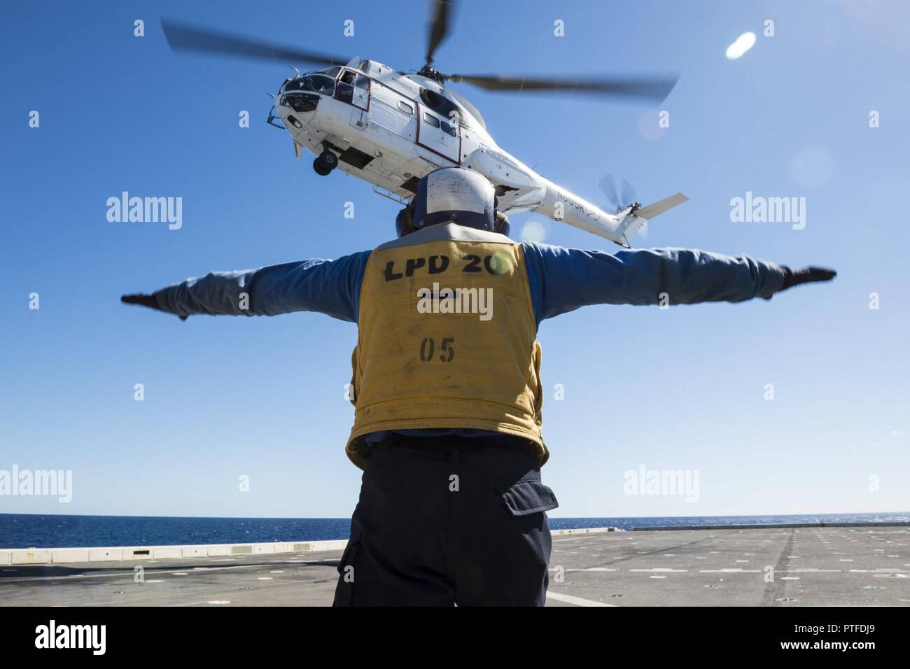 CORAL SEA (July 21, 2017) Aviation Boatswain’s Mate (Handling) Airman Walter Rutherford, from Speedwell, Tenn., directs a SA-330J Puma helicopter, assigned to the Military Sealift Command dry cargo and ammunition ship USNS Richard E. Byrd (T-AKE 4), to drop cargo on the flight deck of the amphibious transport dock USS Green Bay (LPD 20) during a vertical replenishment as a part of Talisman Saber 17. Talisman Saber is a biennial U.S.-Australia bilateral exercise held off the coast of Australia meant to achieve interoperability and strengthen the U.S.-Australia alliance. Stock Photo