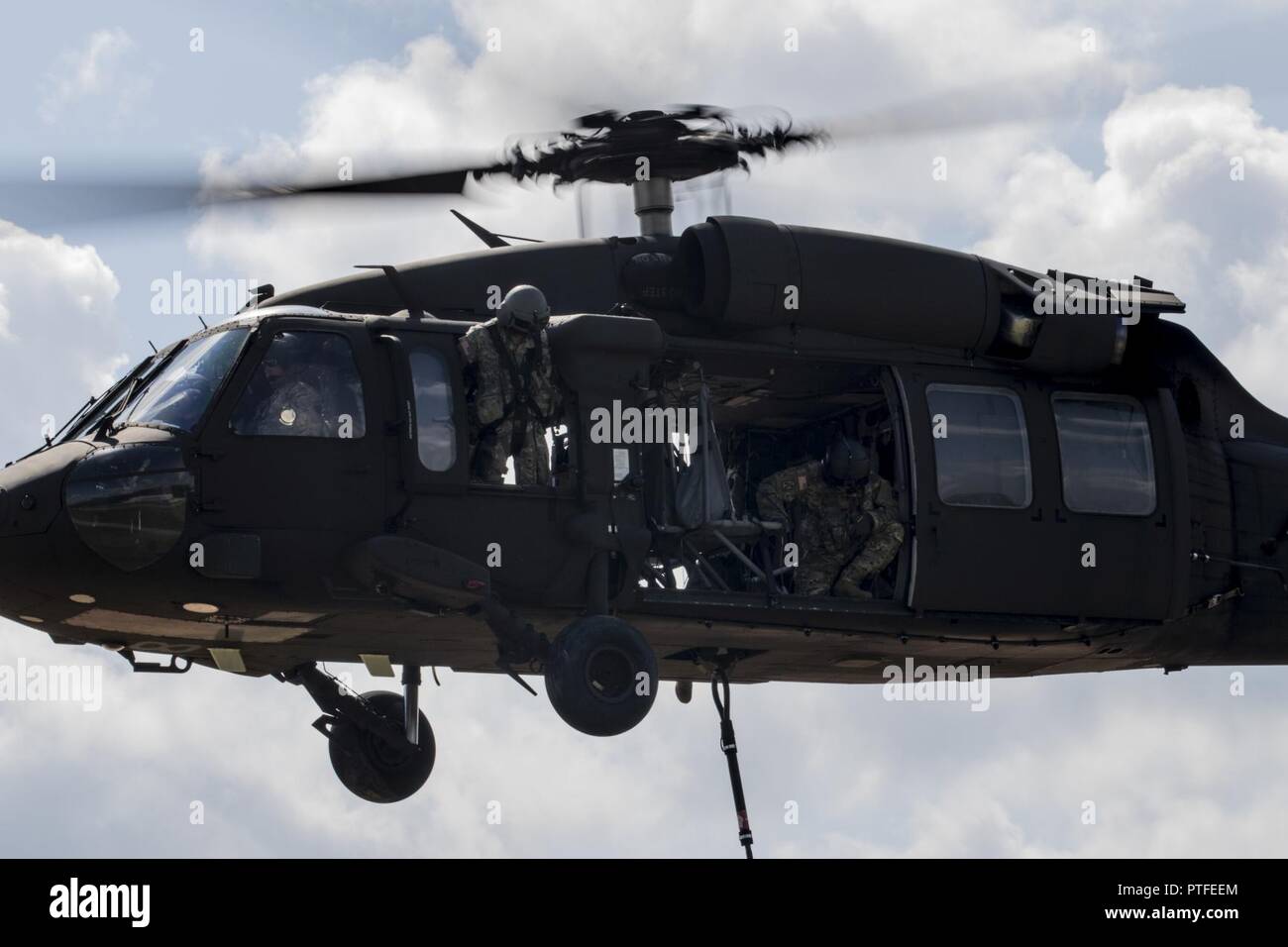 A UH-60 Black Hawk assigned to the 76th Infantry Brigade Combat Team flies away after receiving a sling-load package during sling-load operations at the Joint Readiness Training Center, Fort Polk, Louisiana, Thursday, July 20, 2017. Sling-load operations transports material or vehicles suspended under a helicopter. Stock Photo