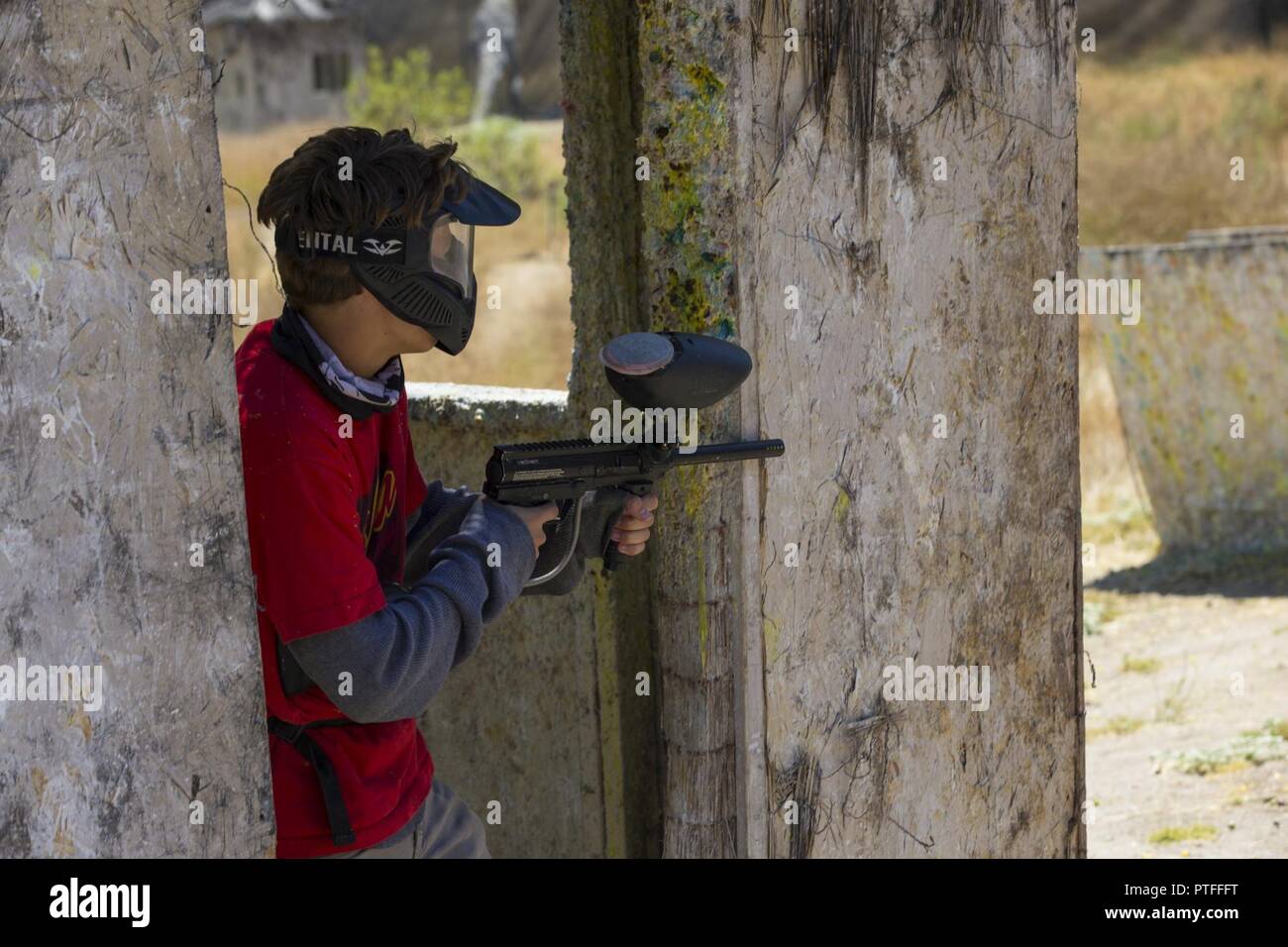 Gavin Kolb, a participant in a game of capture the hill, takes cover from enemy fire at the