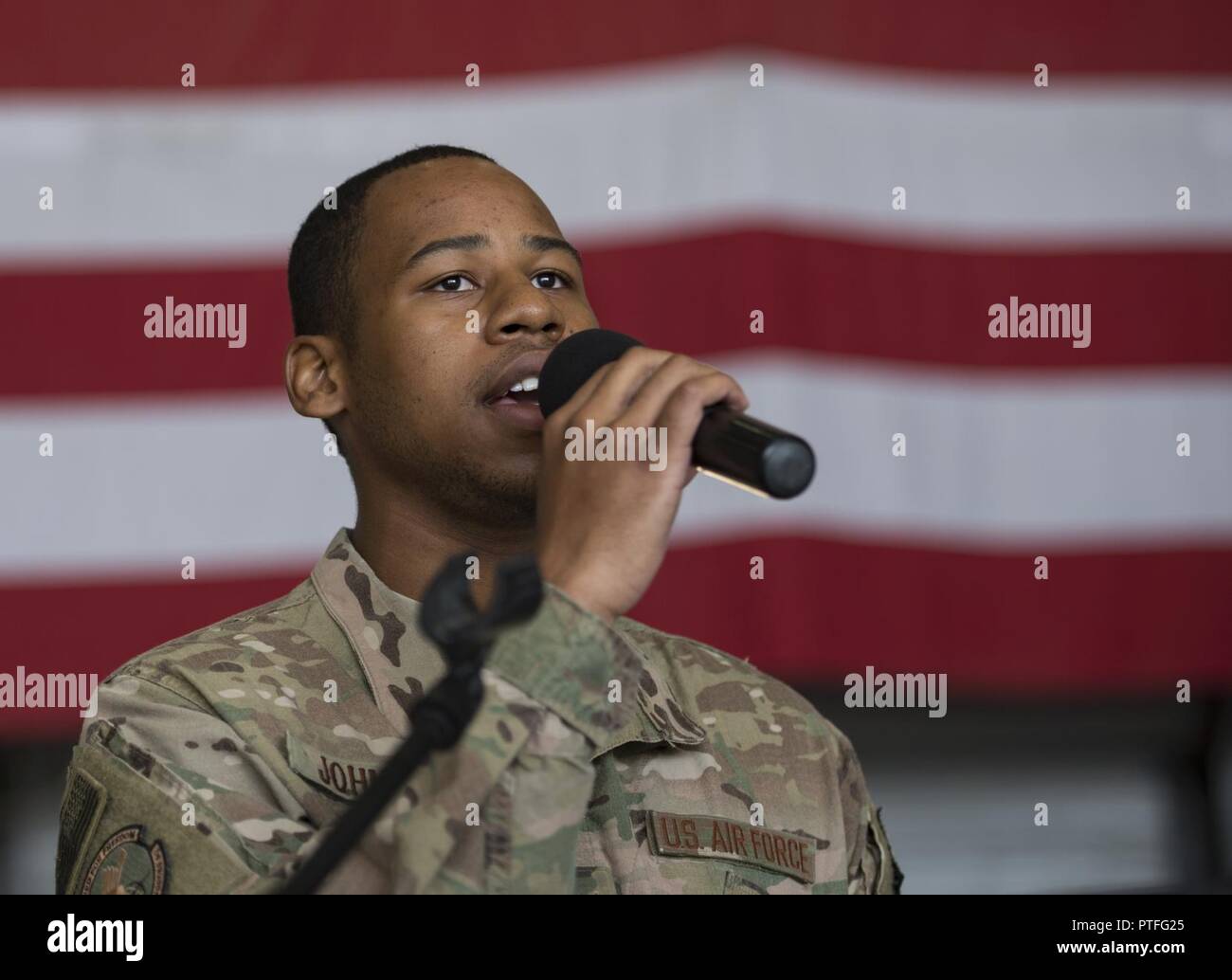 Senior Airman Calvin Johnson, 455th Security Forces Squadron, sings the national anthem during the 455th Expeditionary Mission Support Group change of command ceremony at Bagram Airfield, Afghanistan, July 20, 2017. During the ceremony, Col. Bradford Coley relinquished command of the 455th EMSG to Col. Phillip Noltemeyer. Stock Photo
