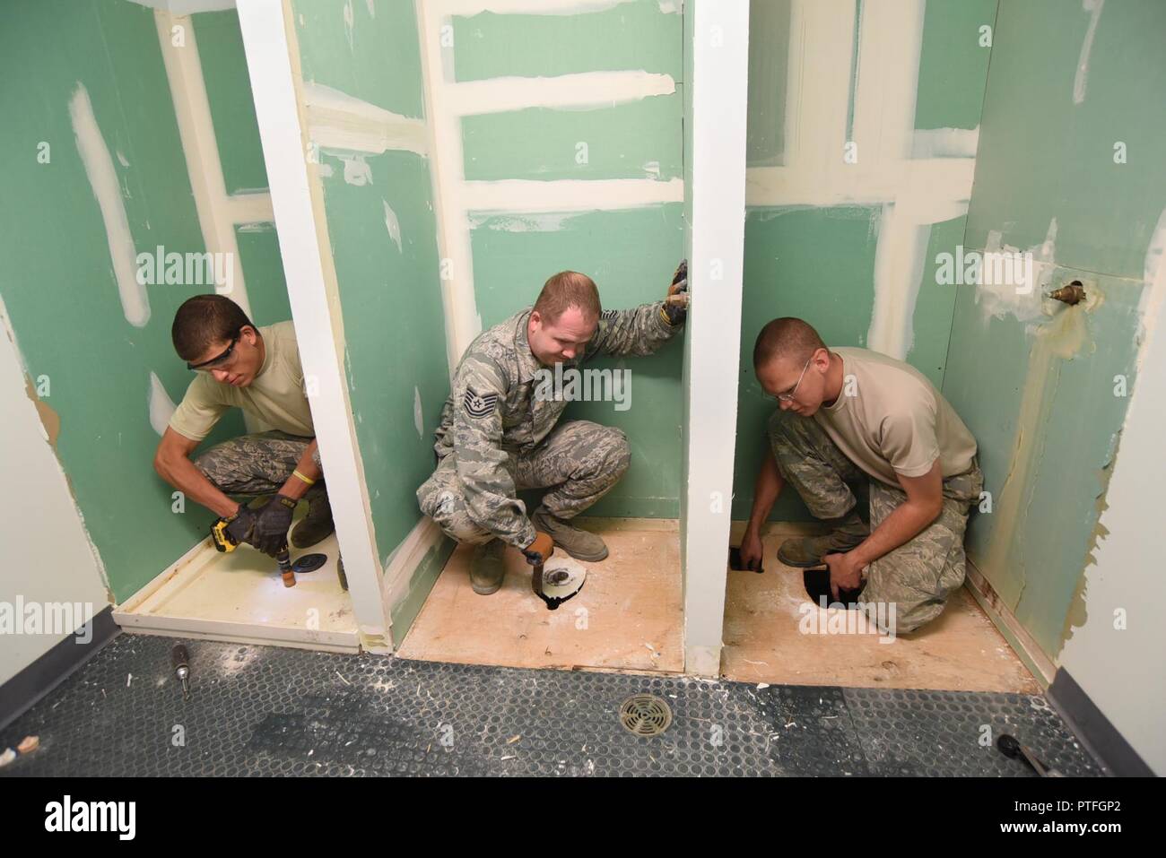 Oregon Air National Guardsman Airman 1st Class Joshua Bietschek (left),  along with Tech. Sgt. Adrian Tate (center) and Staff Sgt. Benjamin Schultz  (right) work on various tasks to rebuild three showers at