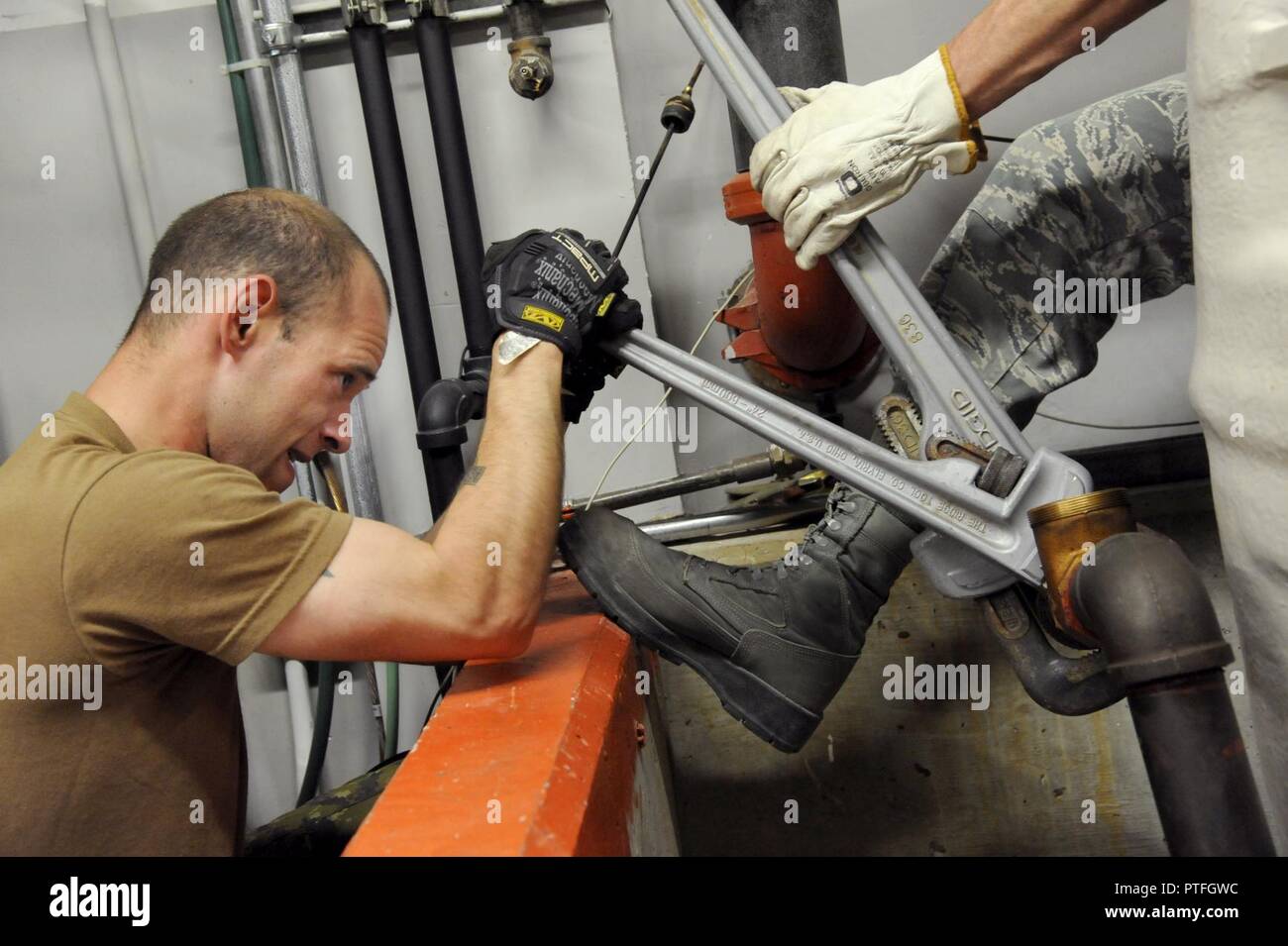 Canadian Armed Forces (CAF) Private Jacob Hodgin (left) works with Oregon Air National Guard Staff Sgt. Michael Templeton (right) as they work to install a new heating fuel tank at the Joint Task Force North (JTFN) Headquarters building, Yellowknife, Northwest Territories, Canada, July 19, 2017. The Oregon CES members are deployed for two-weeks for training along with CAF members from Cold Lake, Alberta. Stock Photo