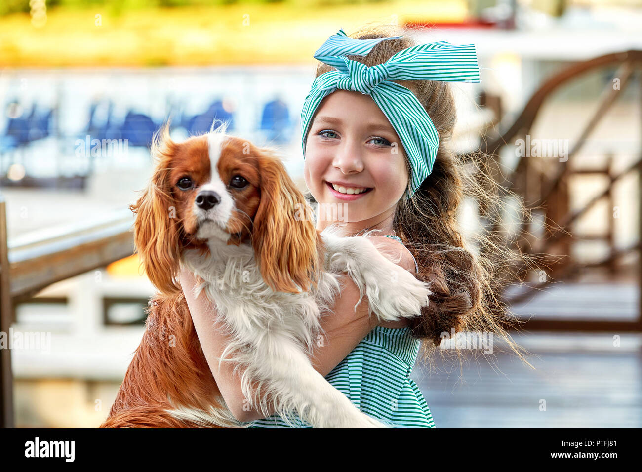 Happy child with dog. Portrait close-up joy face girl hugs puppy breed cocker spaniel, cavalier charles king. Charming cute pet, dog, animal, friendship with kid. Stock Photo