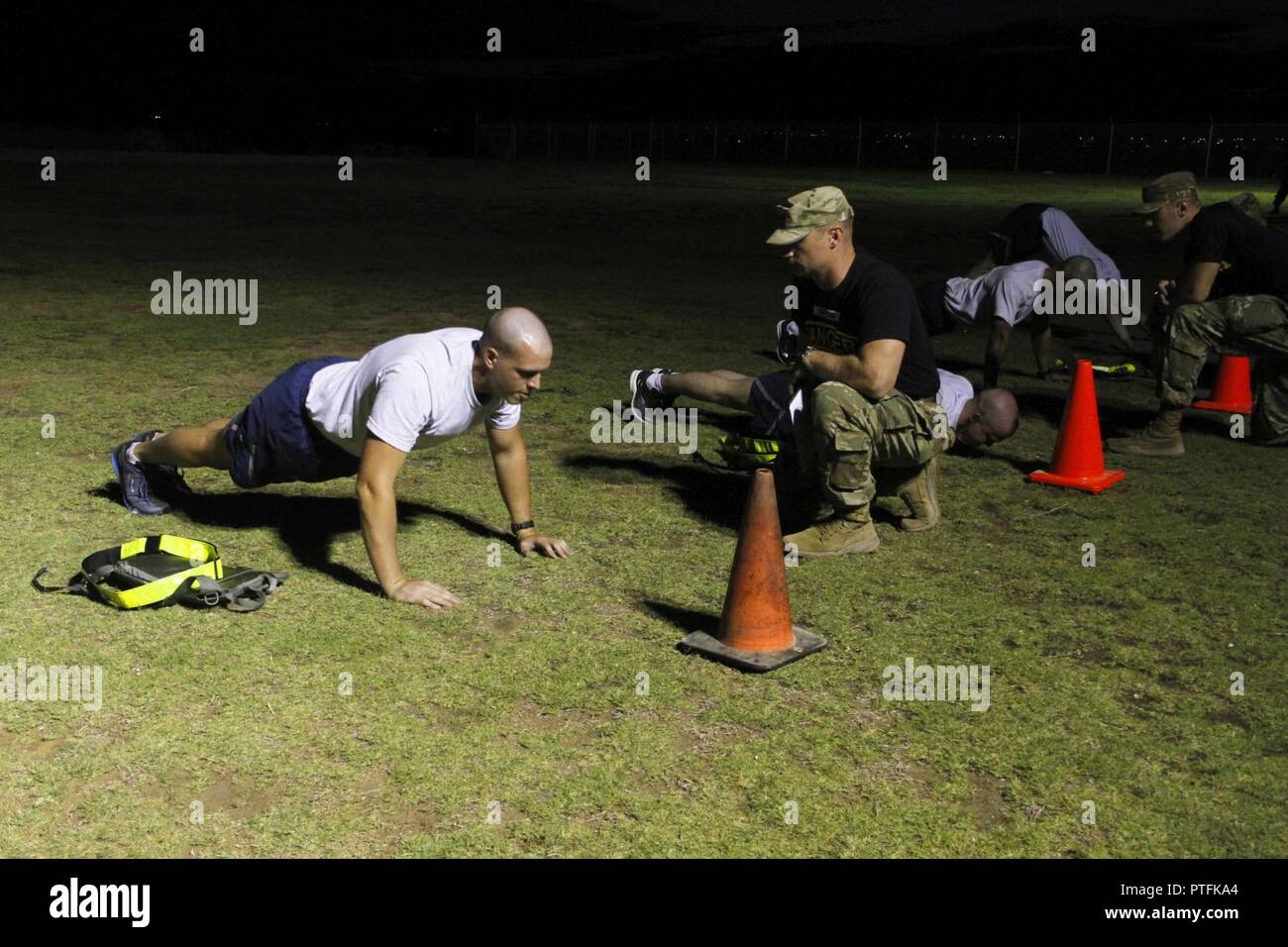 Tech. Sgt. Tom Cook, right, grades an Airman on his pushups during the Ranger Physical Fitness Test to kick off the Ranger Assessment Course at Fort Bliss, Texas July 10, 2017. Ranger School attendees must do 49 push-ups. U.S. Army Stock Photo