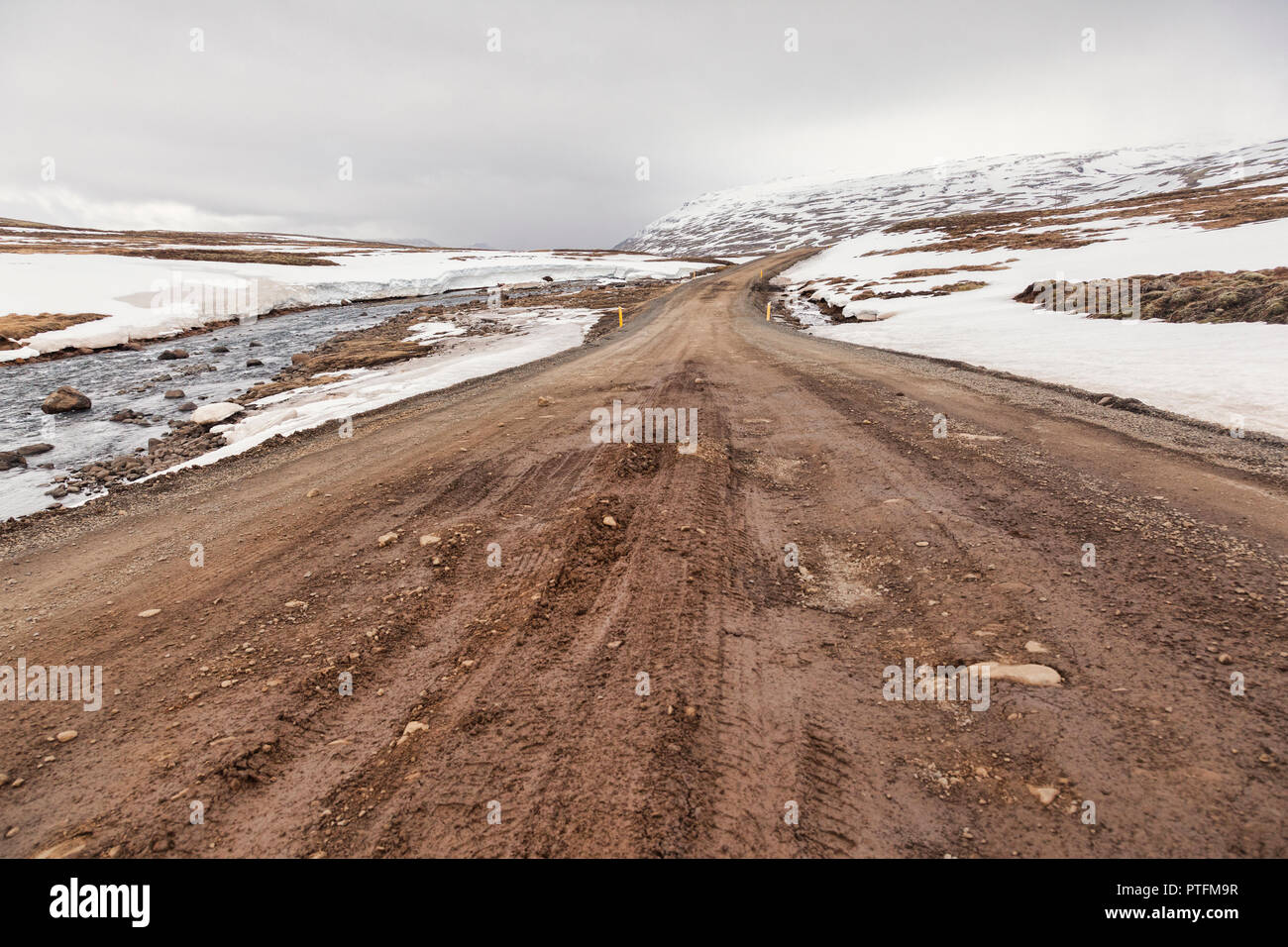 A high level mountain pass through snowy mountains in East Iceland. Stock Photo