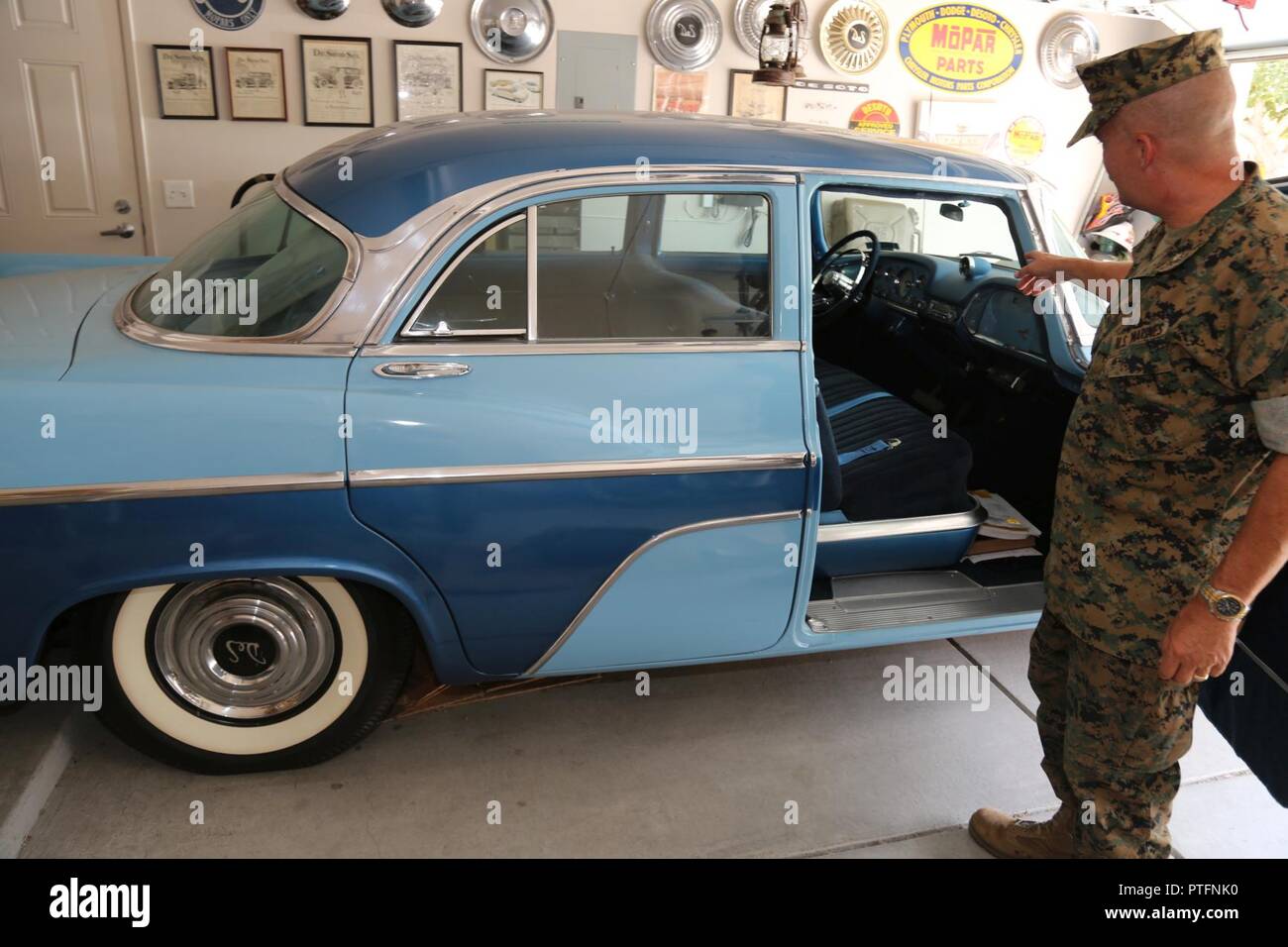 Lieutenant Colonel Timothy Silkowski, director, Fleet Support Division, Marine Corps Logistics Base Barstow, Calif., explains the intricacies of restoring his 1956 DeSoto Firedome. He also owns a Ford World War II Jeep and a Willys Station Wagon both of which he restored. Stock Photo