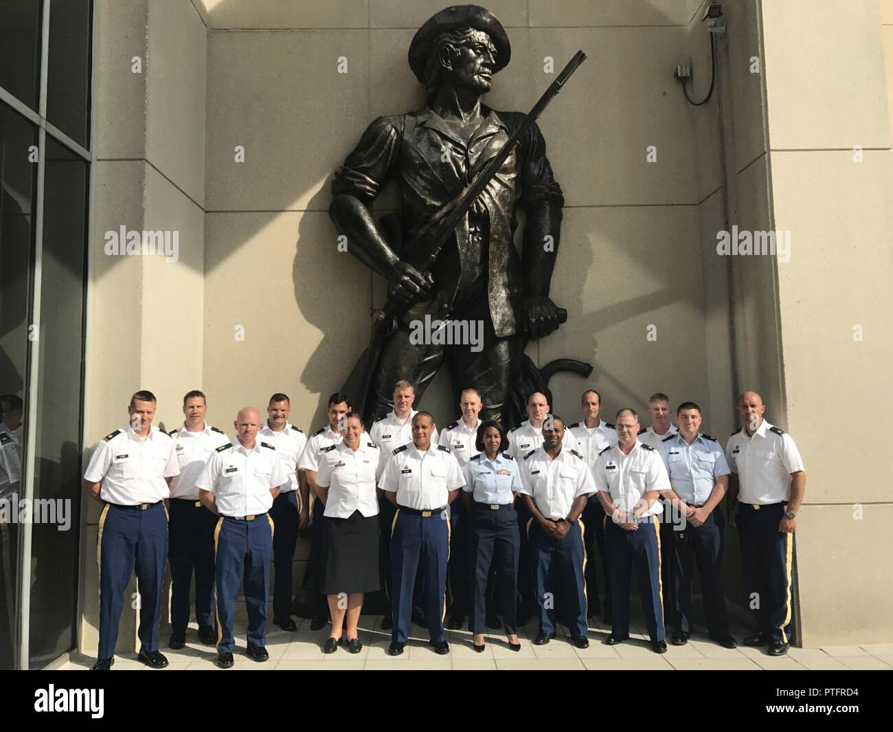 North Carolina National Guard Soldiers and Airmen participating in Operation Potomac stand in front of a minuteman statue at the Army National Guard Readiness Center in Washington, D.C. on July 11, 2017. Operation Potomac provides an opportunity for mid-career officers and warrant officers to gain insight into the strategic level budgeting and policy implementation by traveling to Washington and meeting with members of congress and National Guard Bureau leadership. Stock Photo