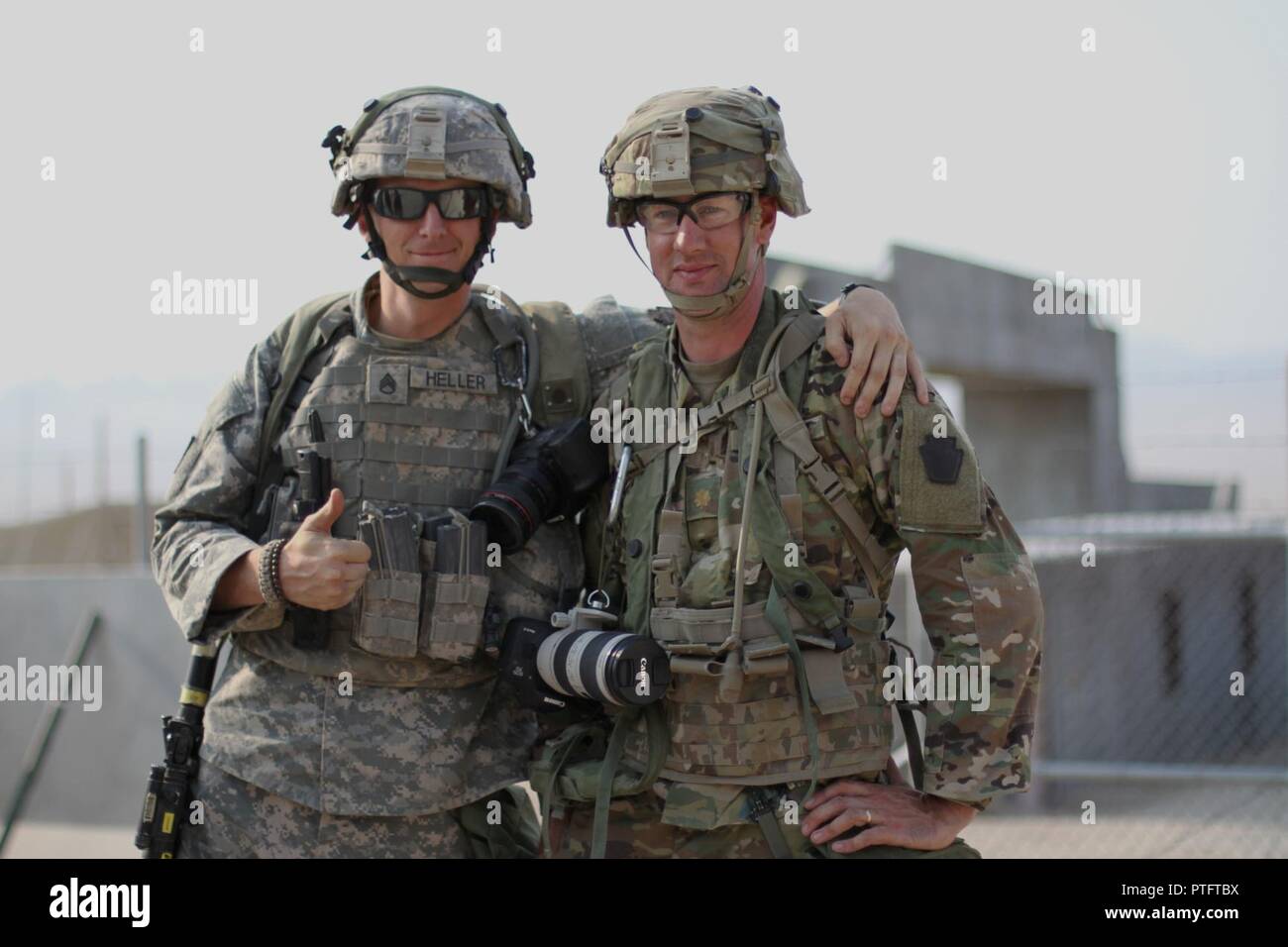Staff Sgt. Coltin Heller (left), a public affairs specialist, and Maj. Greg McElwain (right), the brigade public affairs officer with the 56th Stryker Brigade Combat Team, 28th Infantry Division, Pennsylvania Army National Guard, pose for a picture before a simulated press conference Aug. 10 at the National Training Center, Fort Irwin, Calif. Stock Photo