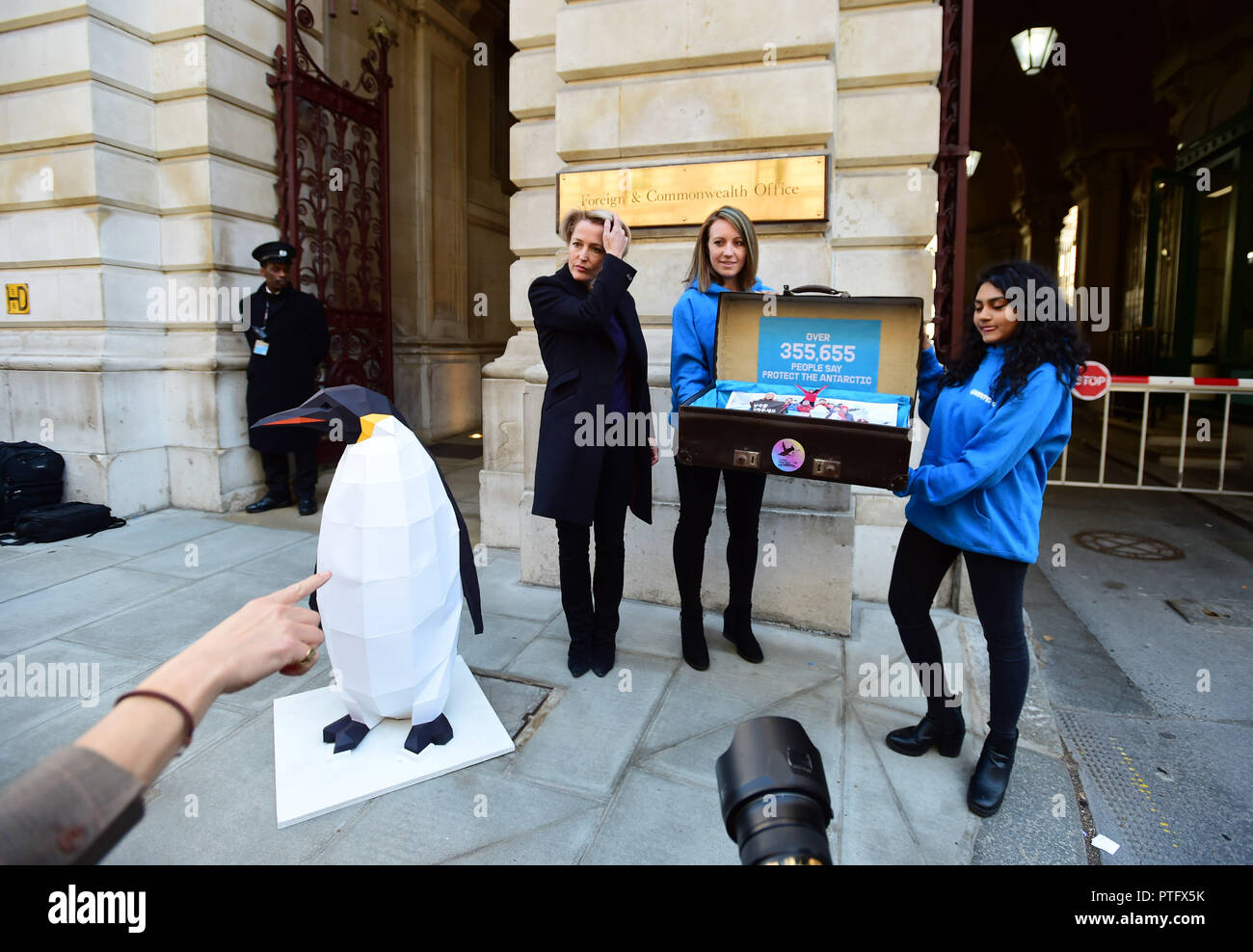 Gillian Anderson (left) with a sculpture of a penguin outside the Foreign & Commonwealth Office in London before delivering a 350,000-strong petition calling on the government to protect the Antarctic. Stock Photo