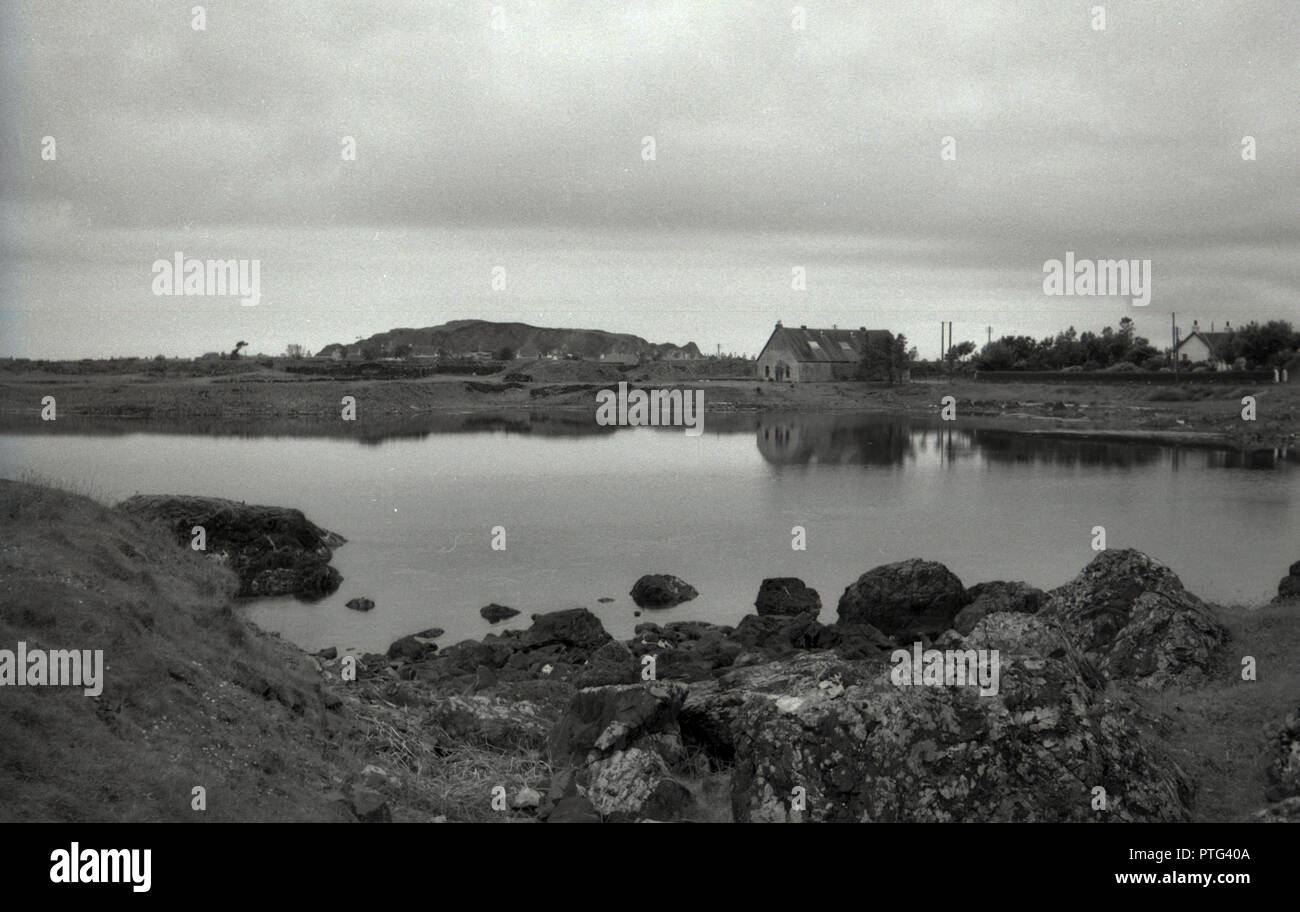 1950s, historical, view of a small church and cottage by a natural inlet on  the Outer Hebrides, Western Isles, Scotland, UK. Stock Photo