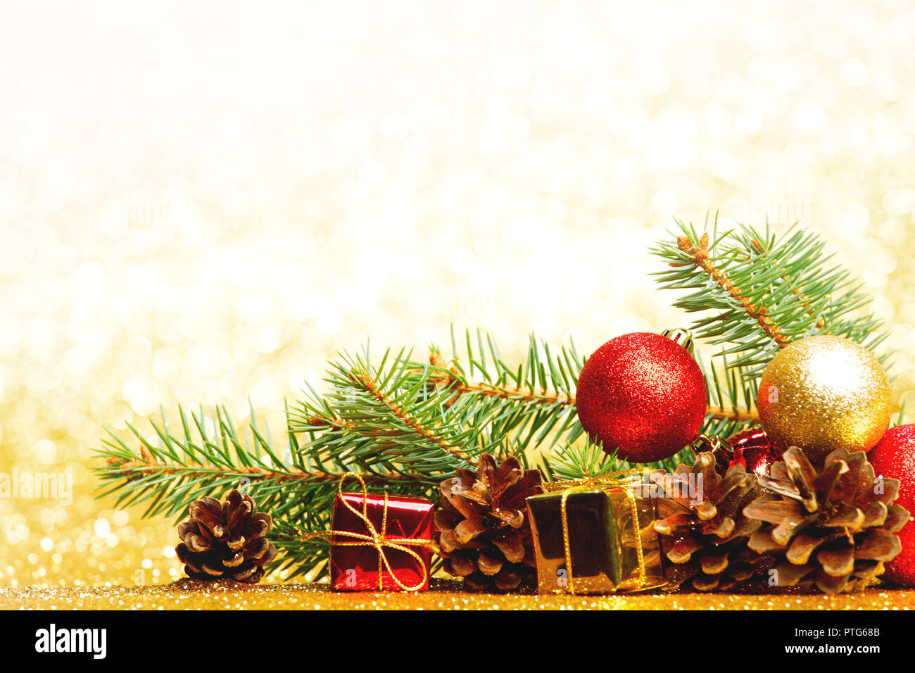 Christmas card with fir tree branch and decoration on golden glitter ...