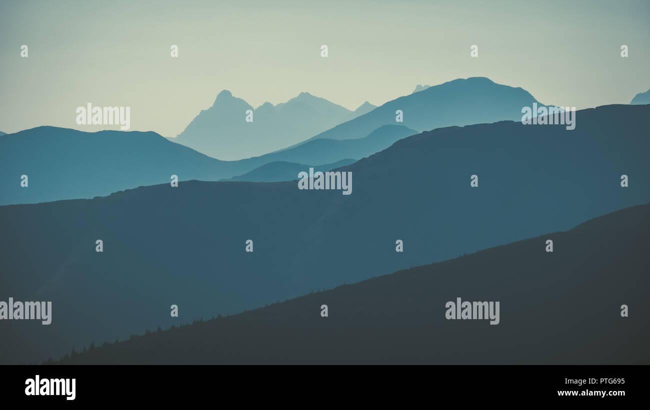 western carpathian mountain tops in autumn covered in mist or clouds ...