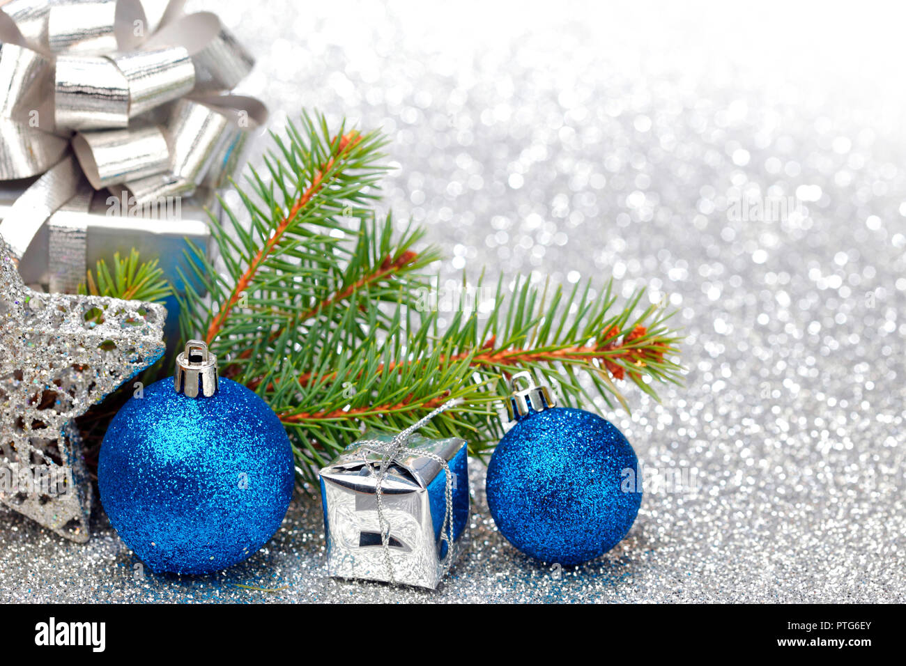 Christmas fir tree branch and decoration on silver glitter background ...