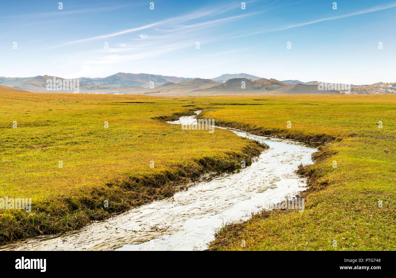 Beautiful grasslands, mountains and meandering rivers are in the distance. Stock Photo