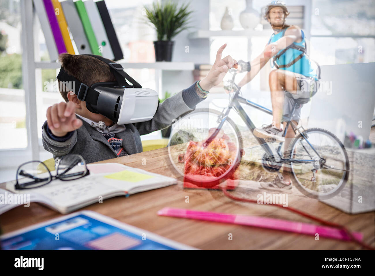 Composite image of boy imitating as business executive using virtual reality headset Stock Photo