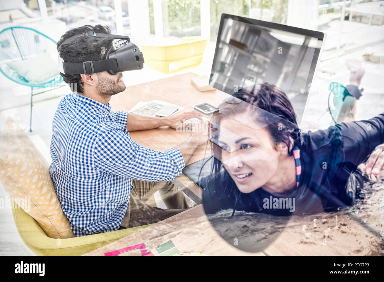 Composite image of graphic designer in virtual reality simulator while using computer Stock Photo