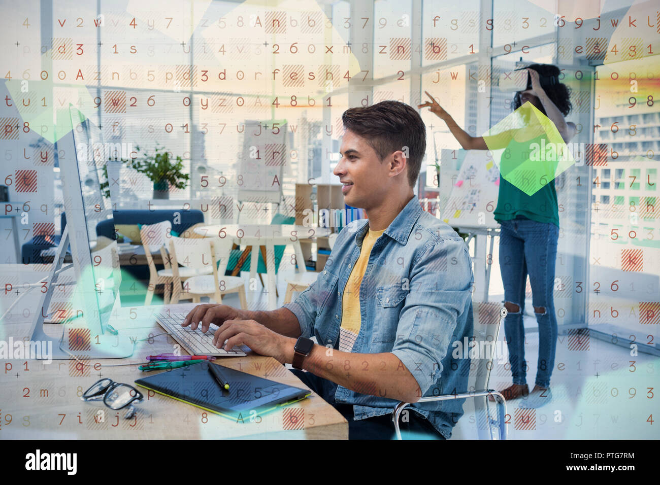 Male executive using computer with colleague in virtual reality headset Stock Photo