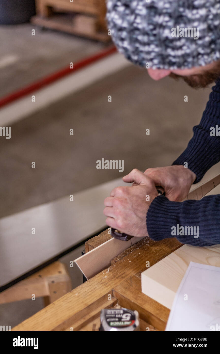 Eco-friendly woodworker's shop. Details and focus on the texture of the material, sawdust, and planers or chisels, while making legs for a table. Stock Photo