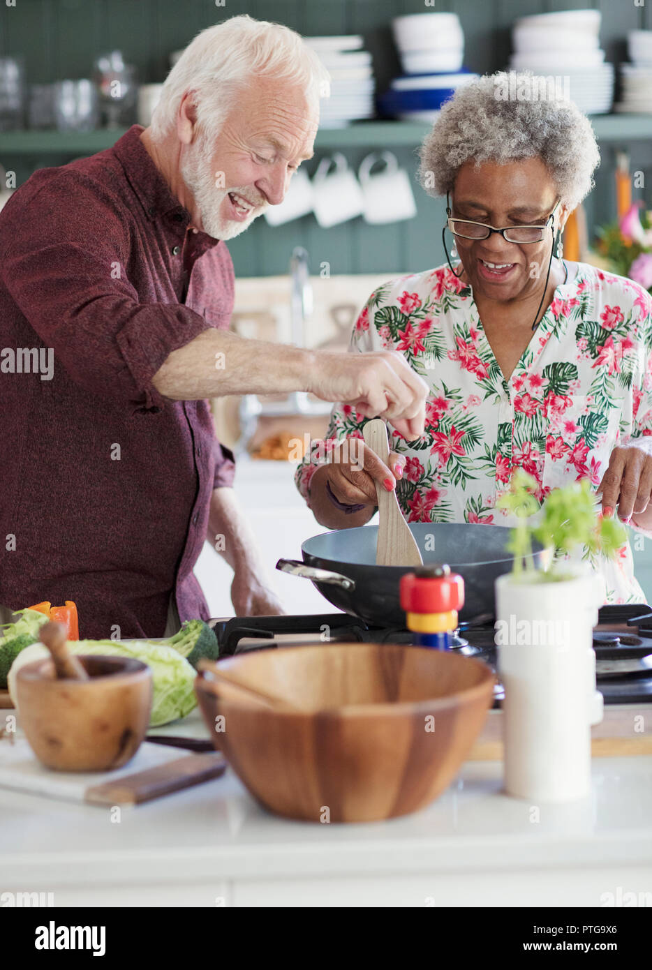 Active senior couple cooking in kitchen Stock Photo