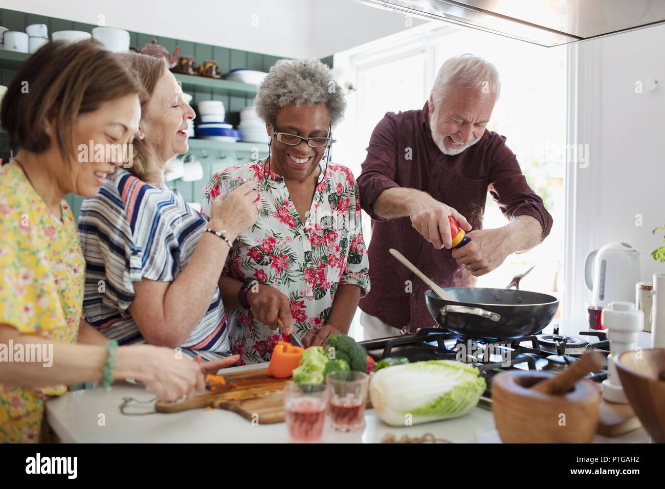 Active senior friends cooking in kitchen Stock Photo