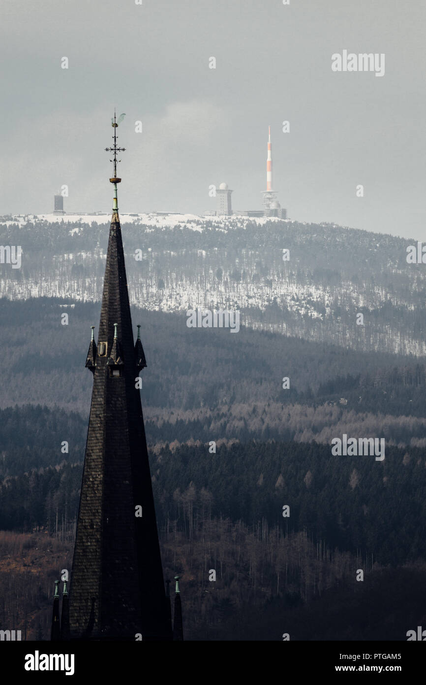 Church spire with a view of the snow-covered Brocken in the Harz Wernigerode. Germany Stock Photo