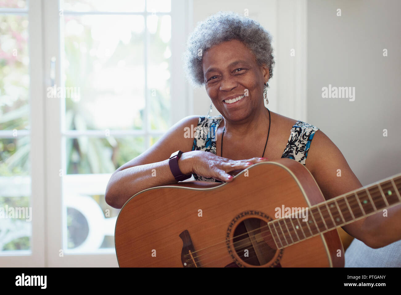 Portrait smiling, confident active senior woman playing guitar Stock Photo