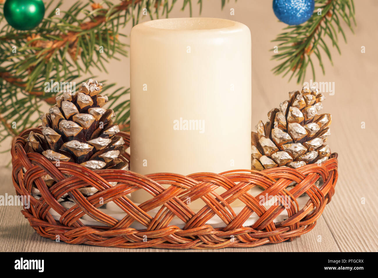 Cones, candle in wicker basket and natural fir tree branches with balls ...