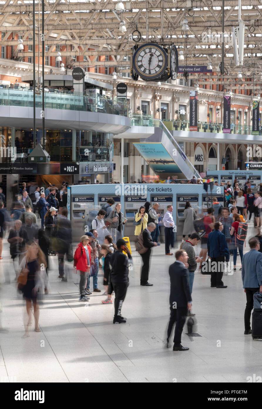 Blurry passengers waiting for their trains at Waterloo Station in London. All shot from the balcony above the concourse. Stock Photo