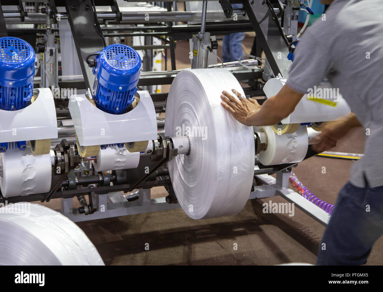 Worker install film roll for extruder machine of polyethylene for