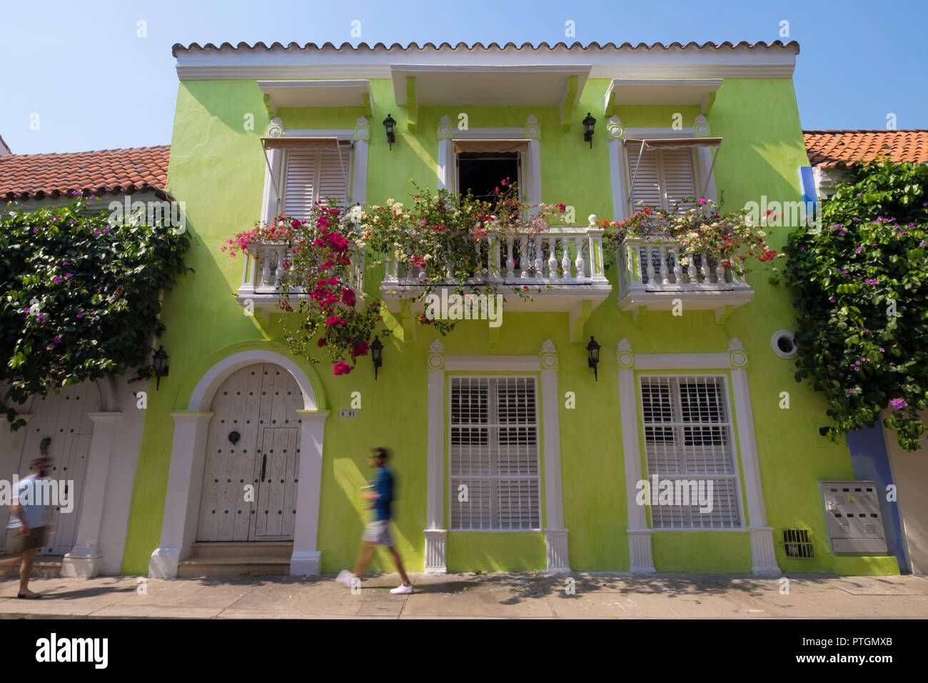 PEOPLE WALKING BY IN THE COLOURFUL STREETS OF CARTAGENA - COLOMBIA Stock Photo