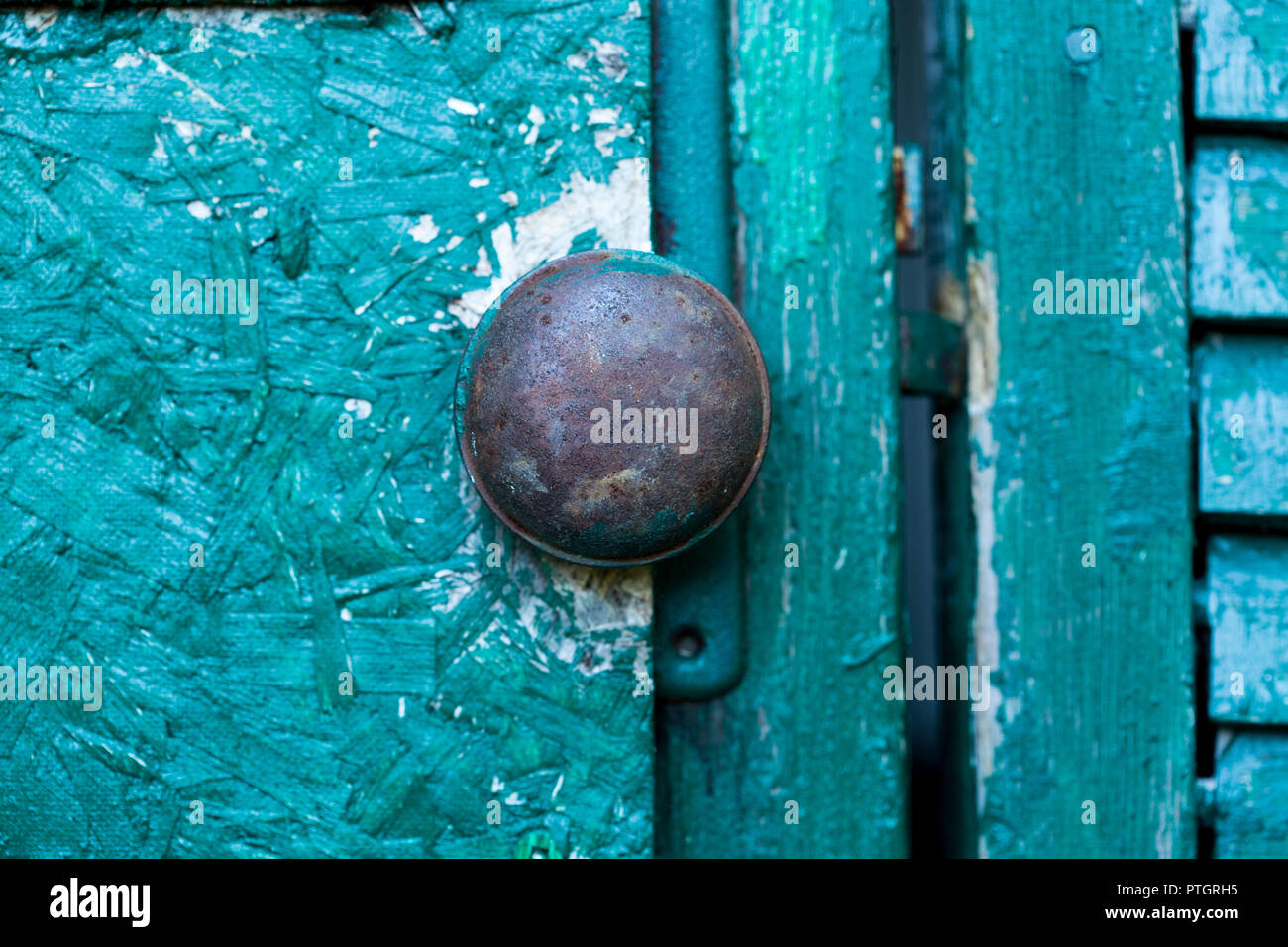 old rusted doorknob on green background Stock Photo