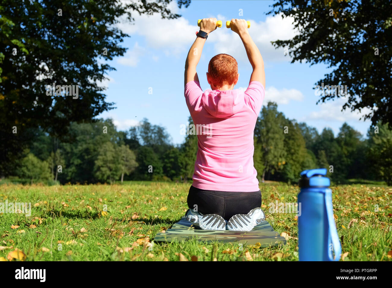 Sporty girl outdoors conducting sport exercises. Healthy lifestyle. Stock Photo