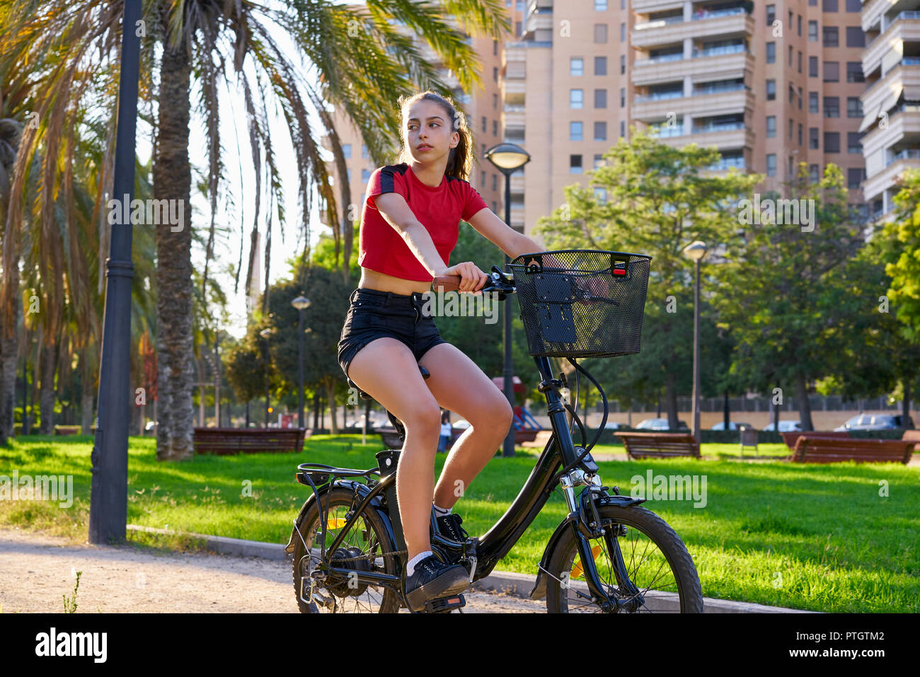Girl riding e-bike in a city park with red t-shirt foldable ebike Stock  Photo - Alamy