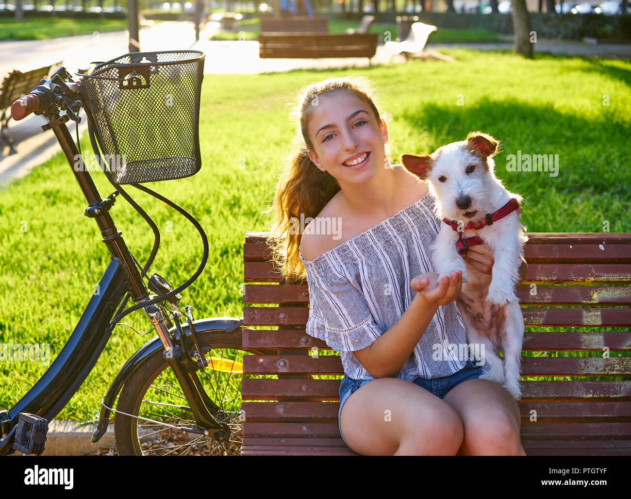 Girl with dog sitting in a park bench with turf grass background ...