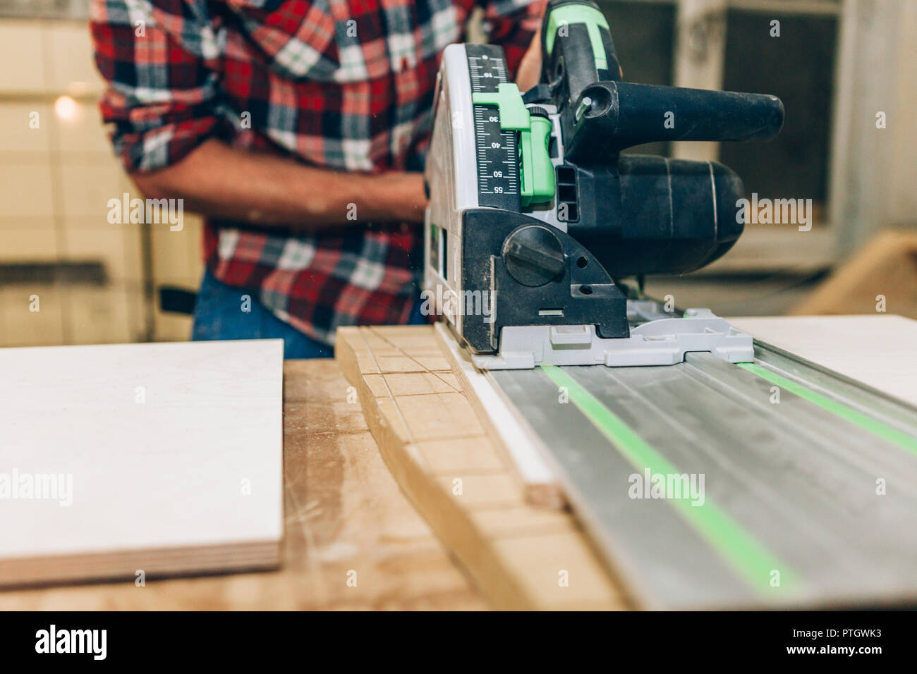 carpenter sawing a wood plank Stock Photo