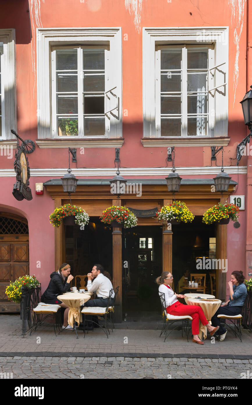 Vilnius old town, view of young people sitting outside a cafe in Pilies Gatve - the main thoroughfare in the center of Vilnius Old Town, Lithuania. Stock Photo