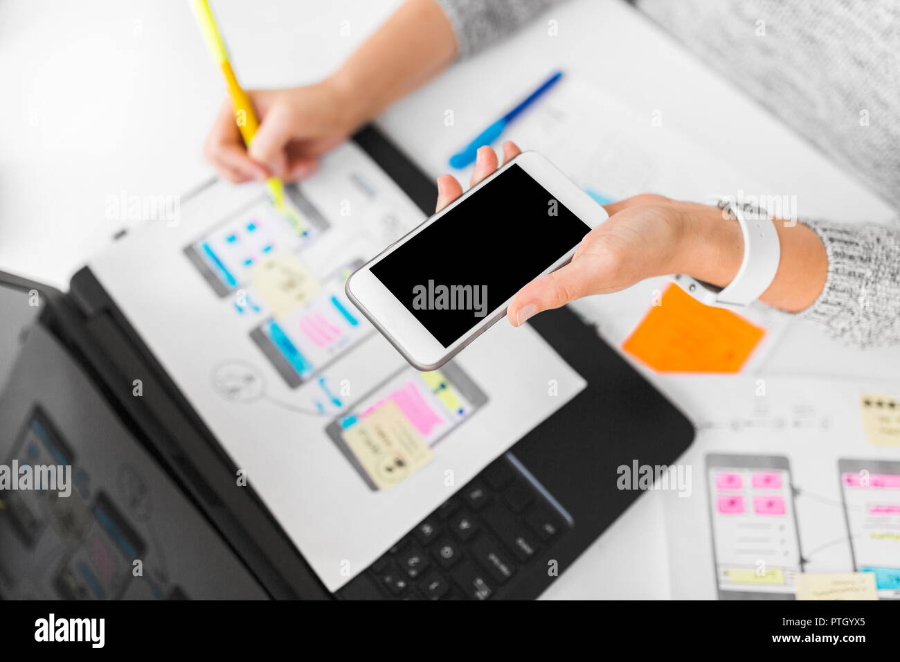 designer with smartphone working on user interface Stock Photo
