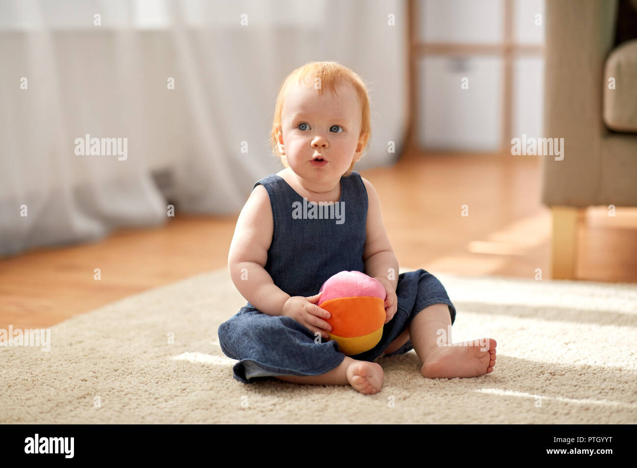 lovely redhead baby girl with toy ball at home Stock Photo - Alamy