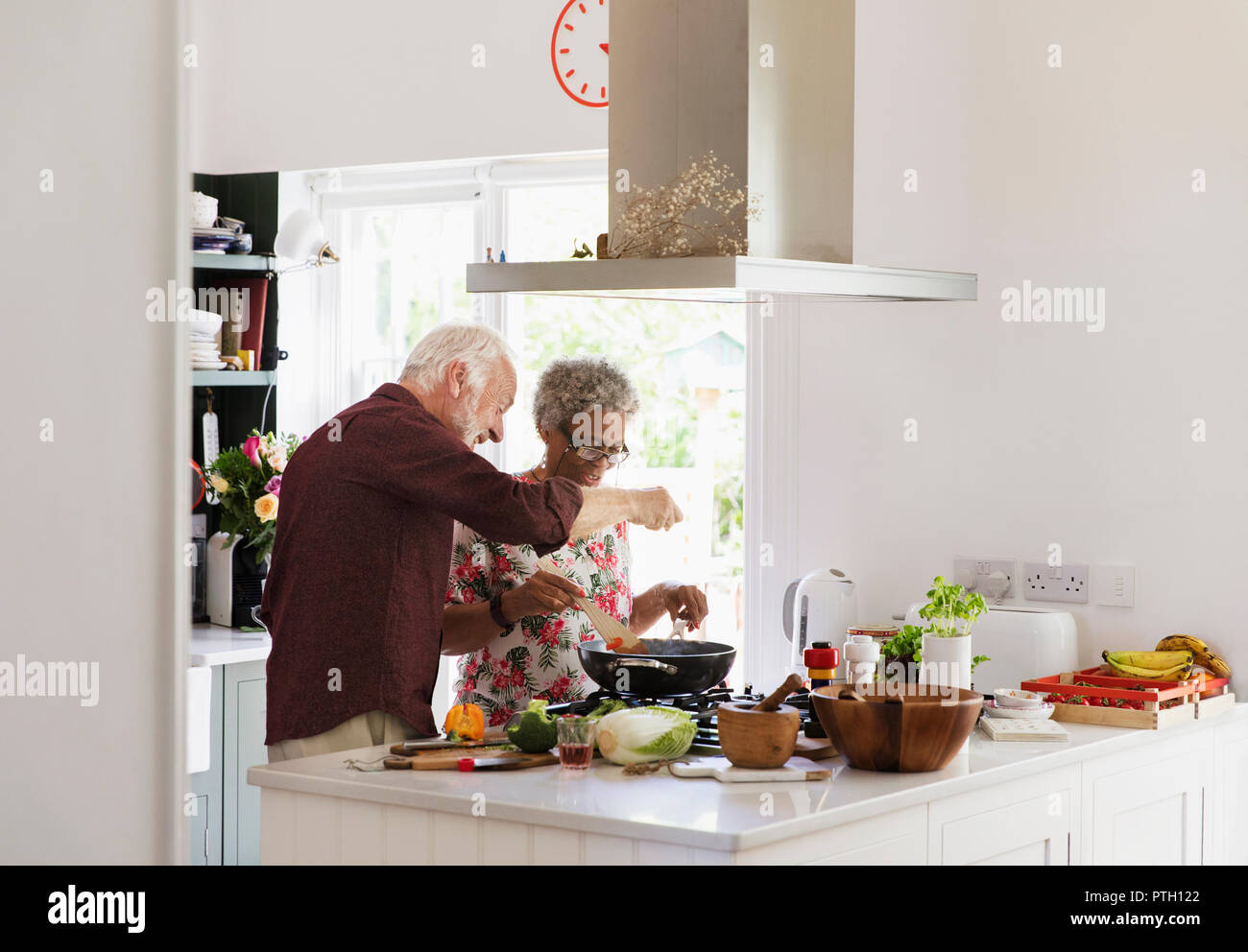 Active senior couple cooking in kitchen Stock Photo